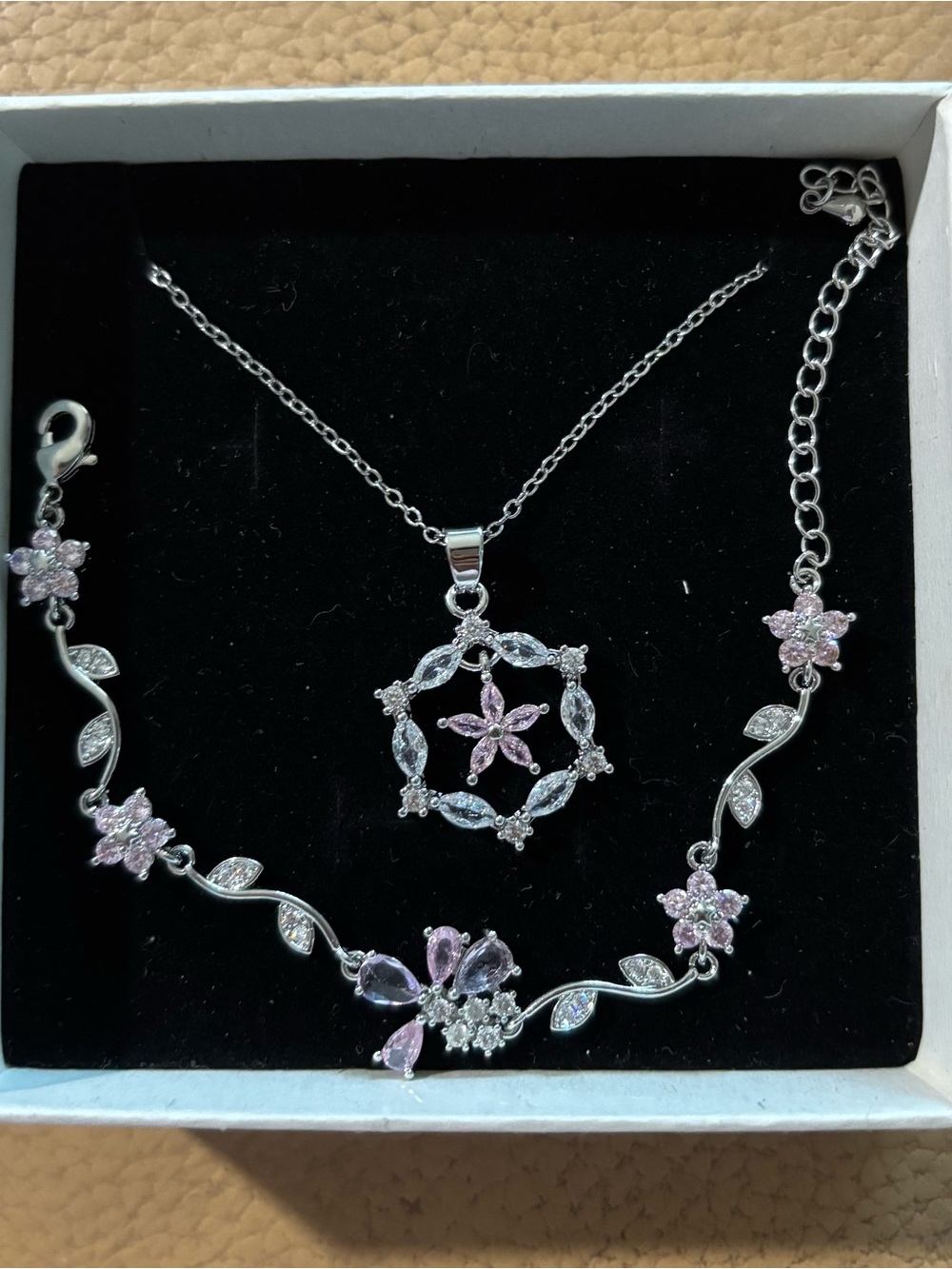 This elegant silver floral jewelry set features a matching necklace and bracelet